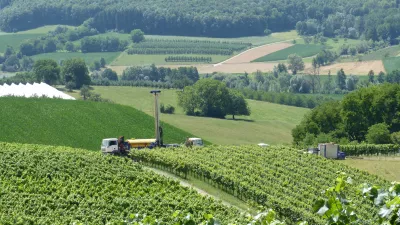 Ein LKW steht auf einem Weg in den Weinbergen und transportiert eine Bohranlage.