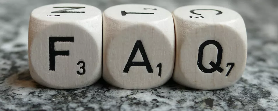 Auf polierten Stein liegen drei weiße Würfel mit den Buchstaben "F" "A" "Q"